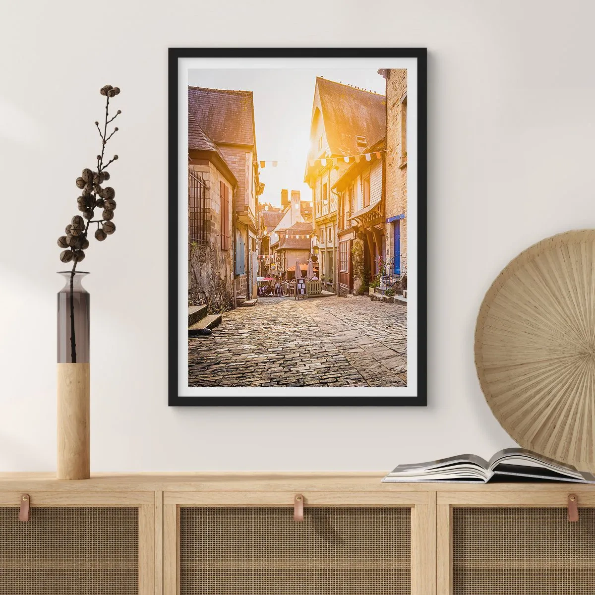 Plakát v černém rámu - Okouzlující ulice s činžovními domy v paprscích zapadajícího slunce - 50x70cm - Bílý duch městečka - Moderní nástěnná dekorace do obývacího pokoje a ložnice ARTTOR