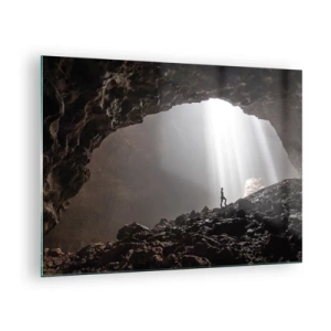 Obraz na skle - Postava v jeskyni osvětlené paprsky světla, obklopená tmavými skalami - 70x50cm - Světelná jeskyně - Moderní nástěnná dekorace do obývacího pokoje a ložnice ARTTOR