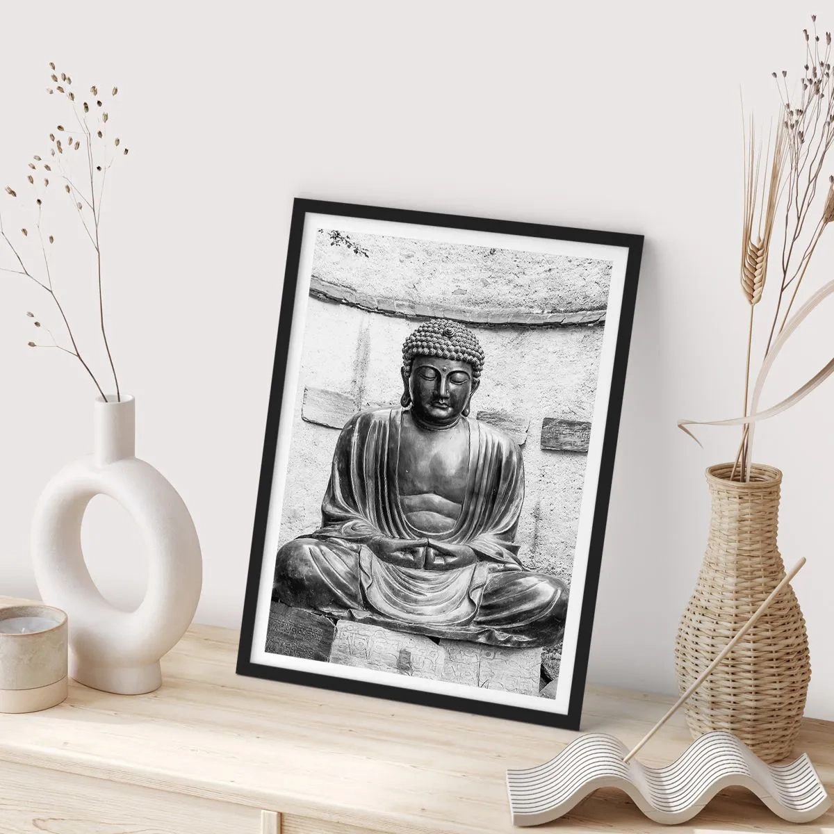 Plakát v černém rámu - Socha Buddhy v meditativní poloze v monochromatických tónech - 50x70cm - U zdroje klidu - Moderní nástěnná dekorace do obývacího pokoje a ložnice ARTTOR