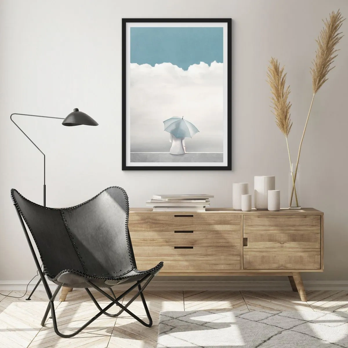 Plakát v černém rámu - Postava s deštníkem sedící na římse mezi mraky - 50x70cm - Na hraně reality a snů - Moderní nástěnná dekorace do obývacího pokoje a ložnice ARTTOR