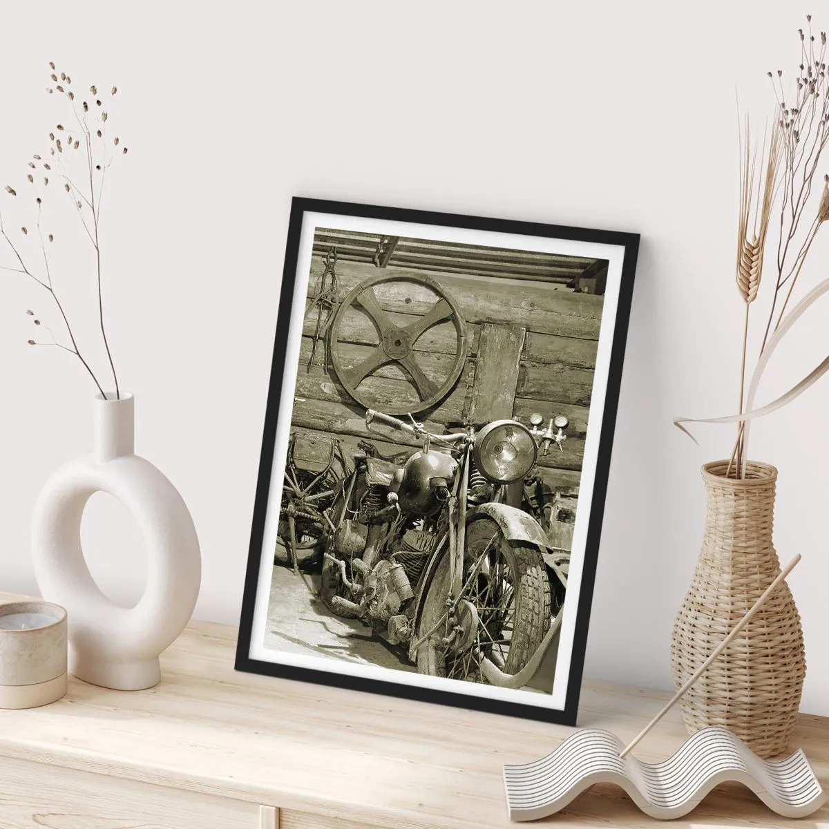 Plakát v černém rámu - Starý motocykl v dřevěné boudě s kolem v pozadí - 50x70cm - V kůlně strýce Vládi - Moderní nástěnná dekorace do obývacího pokoje a ložnice ARTTOR