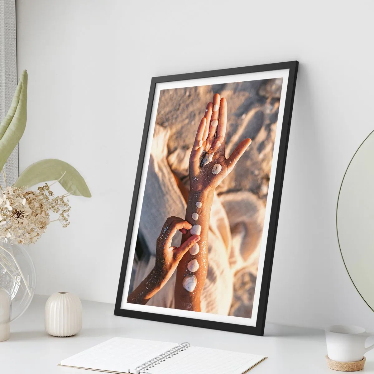 Plakát v černém rámu - Ruce zdobené mušlemi na písčitém pozadí - 50x70cm - Krása na dosah - Moderní nástěnná dekorace do obývacího pokoje a ložnice ARTTOR
