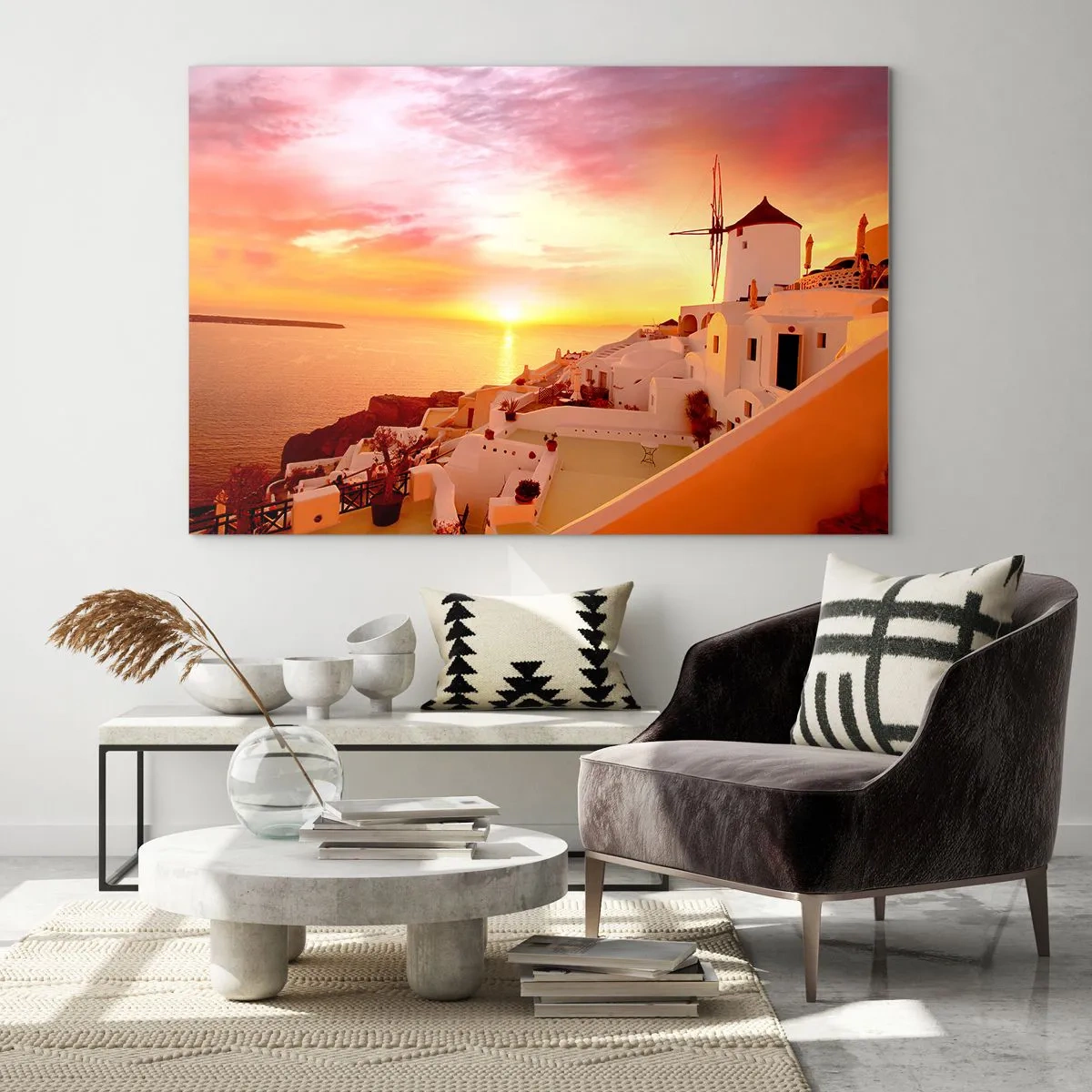 Obraz na skle - Západ slunce nad Santorini s bílými budovami a větrným mlýnem - 70x50cm - Rozplynout se v bílé a zlaté - Moderní nástěnná dekorace do obývacího pokoje a ložnice ARTTOR