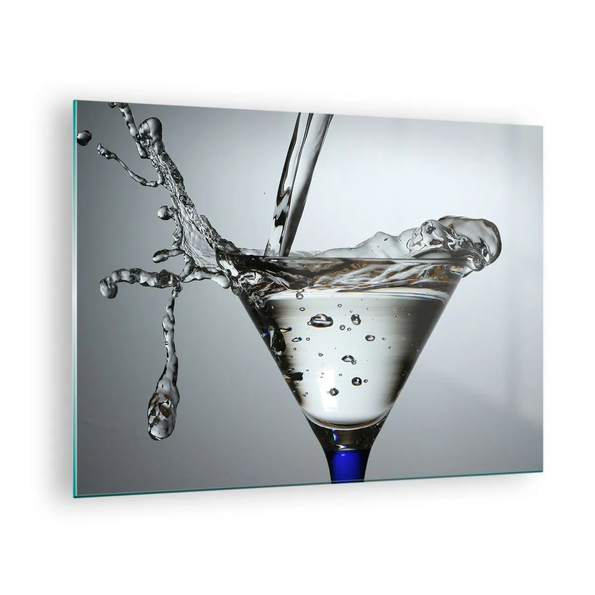 Obraz na skle - Tekutina ve sklenici na martini stříkající na šedém pozadí - 70x50cm - Nad okrajem poháru - Moderní nástěnná dekorace do obývacího pokoje a ložnice ARTTOR
