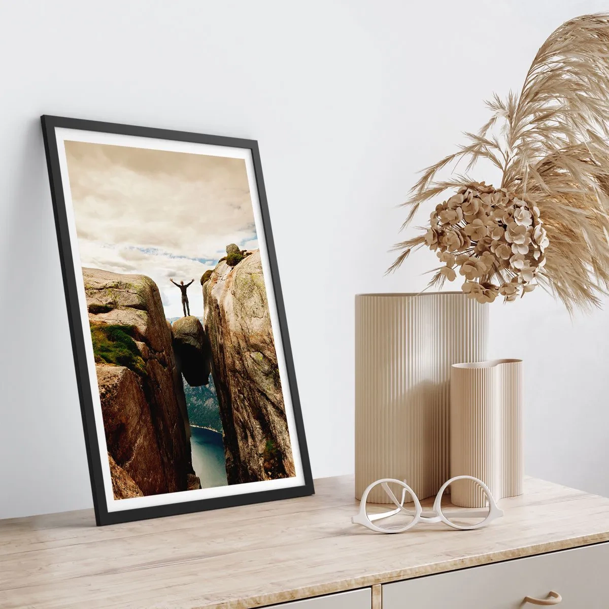 Plakát v černém rámu - Muž stojící na skále zavěšené mezi útesy - 50x70cm - Jak se cítím?! - Moderní nástěnná dekorace do obývacího pokoje a ložnice ARTTOR