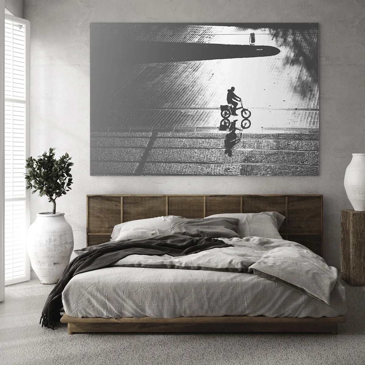 Obraz na skle - Muž jedoucí na kole městem, odraz ve vodě, černobílý záběr - 70x50cm - Dopředu, přes město - Moderní nástěnná dekorace do obývacího pokoje a ložnice ARTTOR