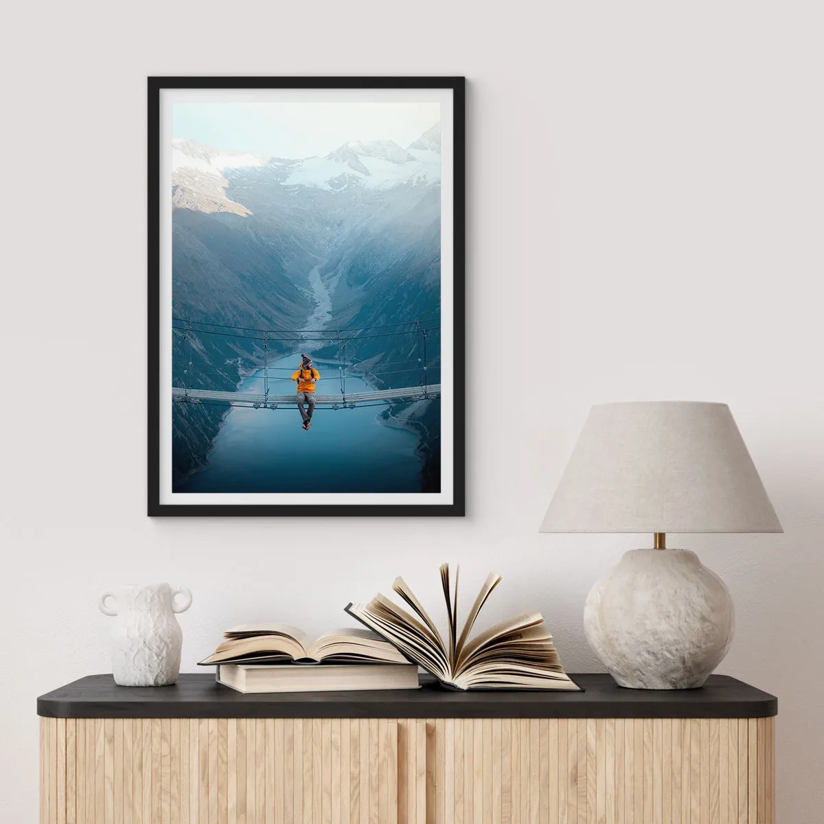 Plakát v černém rámu - Osoba ve žluté bundě sedící na visutém mostě nad údolím - 50x70cm - Okouzlený v spánku - Moderní nástěnná dekorace do obývacího pokoje a ložnice ARTTOR