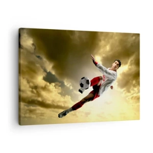Obraz na plátně - Fotbalista v dynamickém skoku kope míč proti obloze - 70x50cm - Fotbalové nebe - Moderní nástěnná dekorace do obývacího pokoje a ložnice ARTTOR