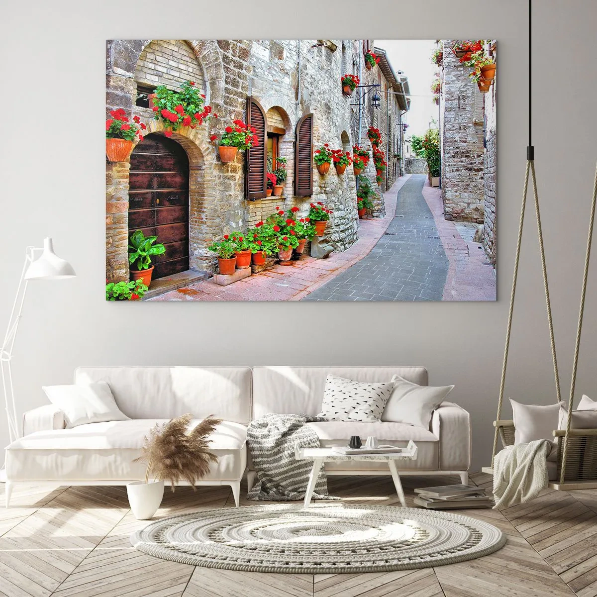 Obraz na skle - Malebná ulice s kamennými zdmi a červenými květinami - 70x50cm - Italská atmosféra - Moderní nástěnná dekorace do obývacího pokoje a ložnice ARTTOR