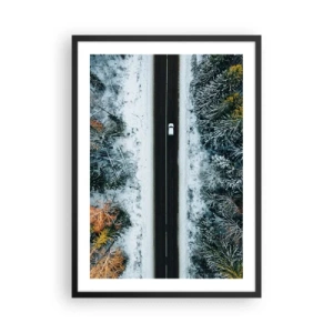 Plakát v černém rámu - Pohled z ptačí perspektivy na zimní les s cestou a jediným autem - 50x70cm - Přes zimní les - Moderní nástěnná dekorace do obývacího pokoje a ložnice ARTTOR