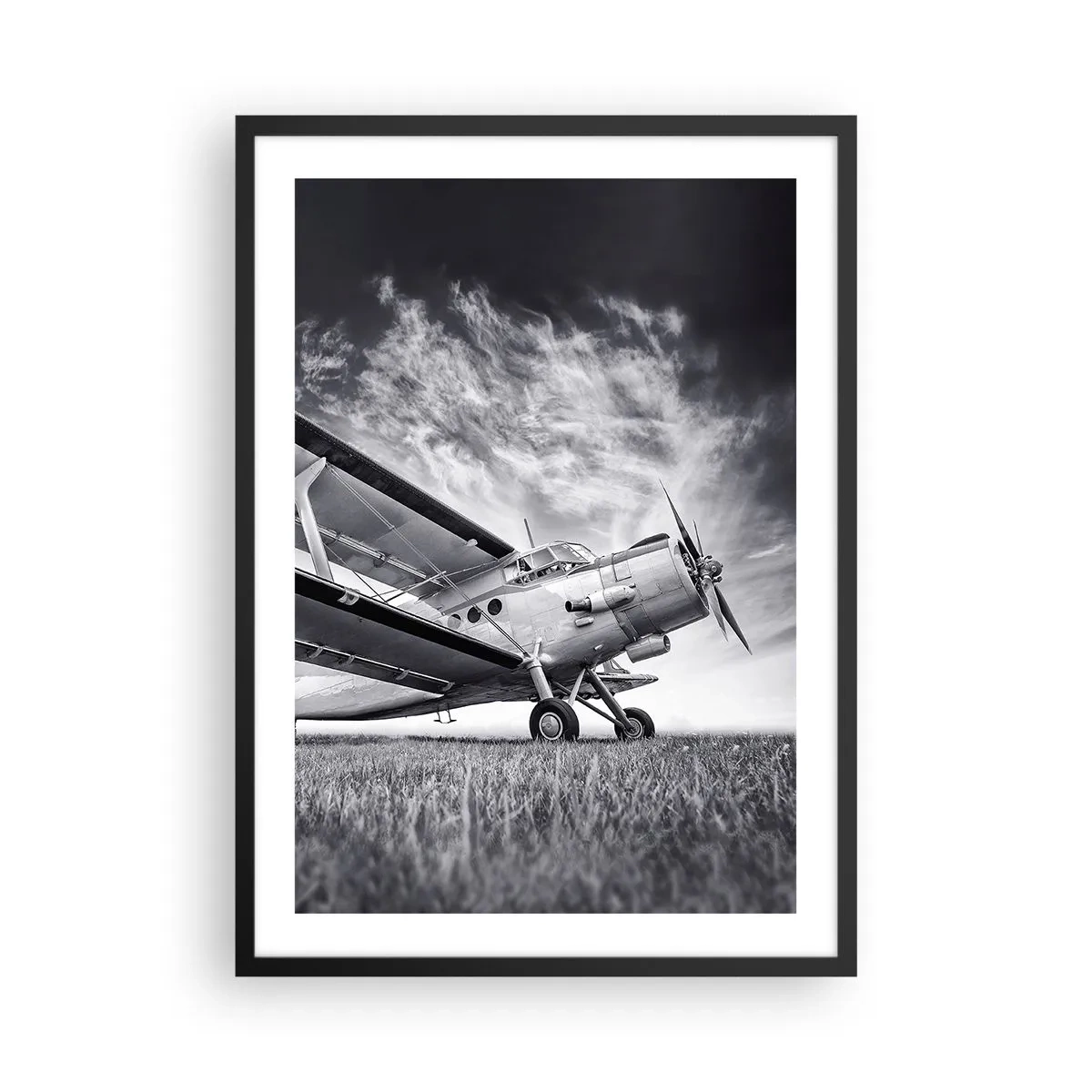 Plakát v černém rámu - Černobílý obraz letadla na pozadí dynamické oblohy. - 50x70cm - Okřídlený poutník - Moderní nástěnná dekorace do obývacího pokoje a ložnice ARTTOR