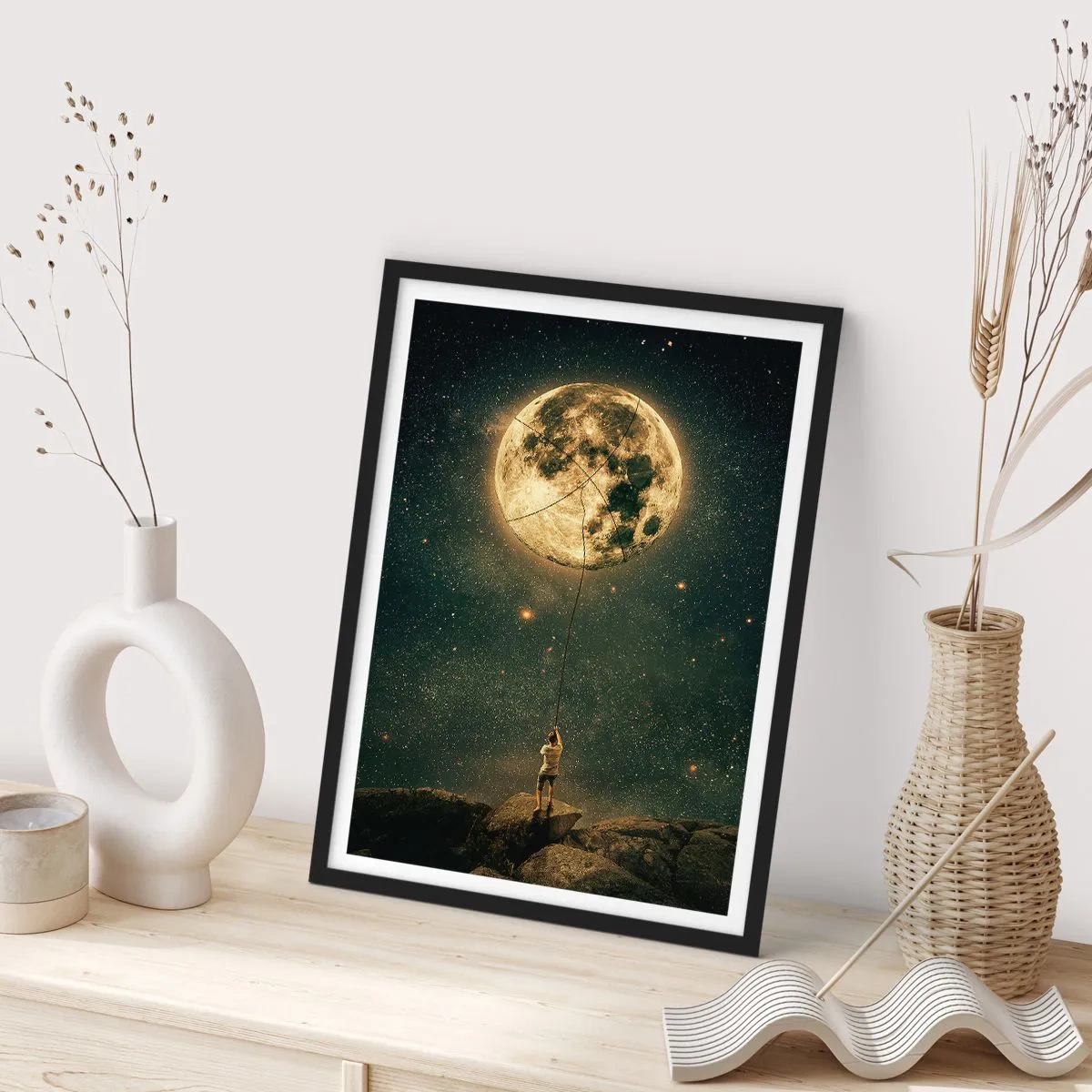 Plakát v černém rámu - Postava držící měsíc na laně v hvězdné krajině. - 50x70cm - Kluk, který ukradl měsíc - Moderní nástěnná dekorace do obývacího pokoje a ložnice ARTTOR