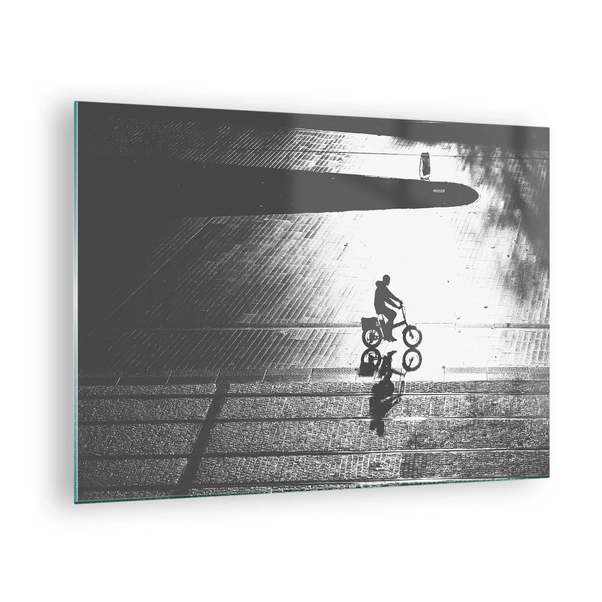 Obraz na skle - Muž jedoucí na kole městem, odraz ve vodě, černobílý záběr - 70x50cm - Dopředu, přes město - Moderní nástěnná dekorace do obývacího pokoje a ložnice ARTTOR