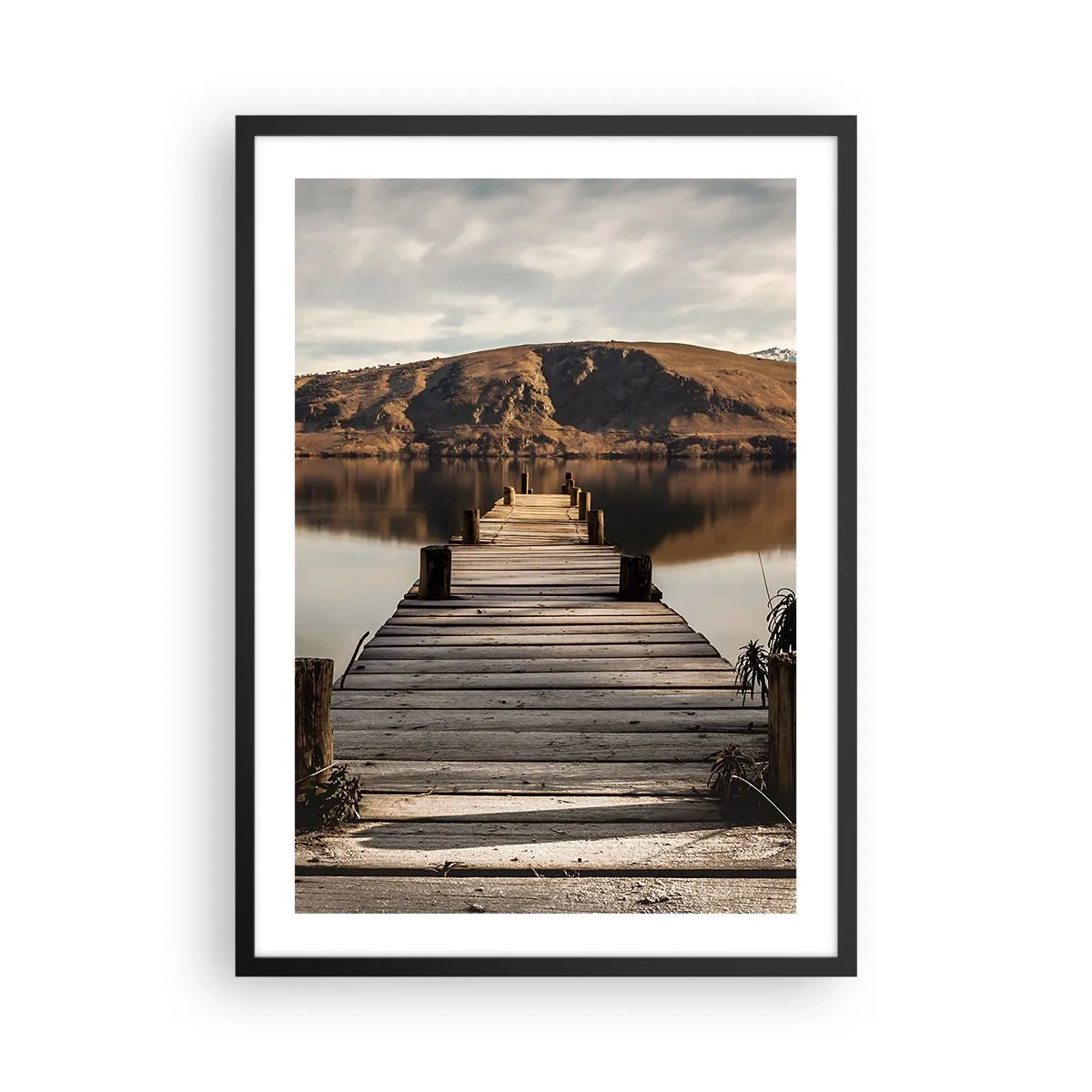 Plakát v černém rámu - Dřevěné molo vede k klidnému jezeru s horskou kulisou - 50x70cm - Krajina v tichu - Moderní nástěnná dekorace do obývacího pokoje a ložnice ARTTOR